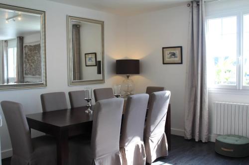 une salle à manger avec une table et des chaises blanches dans l'établissement Villa DUXCAAR Avel Mor, à Guissény
