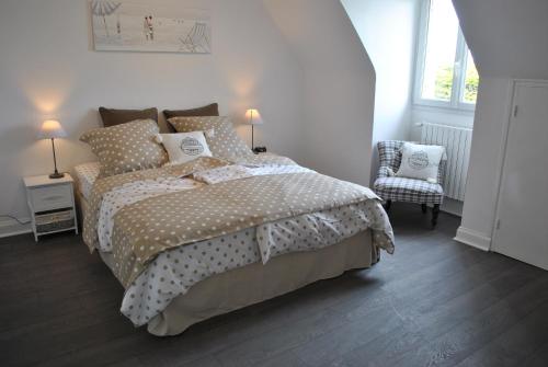 - une chambre blanche avec un lit et une chaise dans l'établissement Villa DUXCAAR Avel Mor, à Guissény