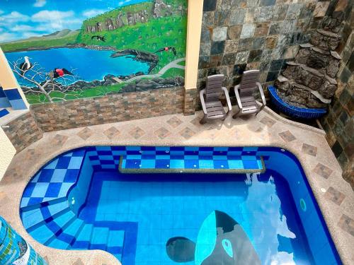 a swimming pool with a painting on the side of a house at GRAND SUN'S HOUSE in Puerto Baquerizo Moreno