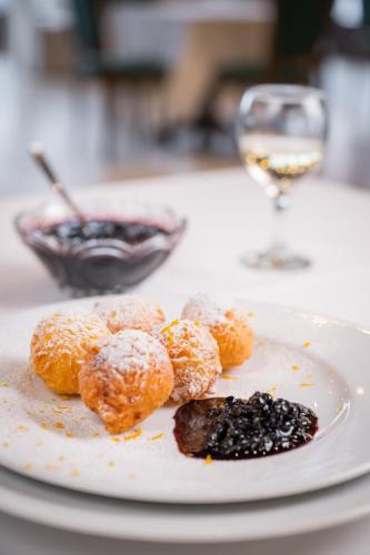 a plate of donuts and a glass of wine at Monterai Resort in Poiana Brasov