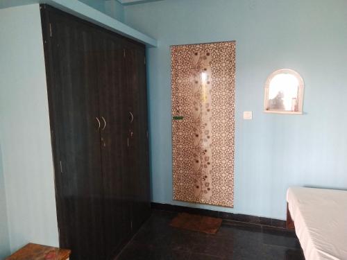 pokój z drzwiami i ścianą z oknem w obiekcie Sri Kavimany Residency w mieście Kālapettai