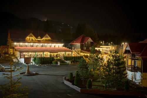 a large building with lights on at night at Monterai Resort in Poiana Brasov