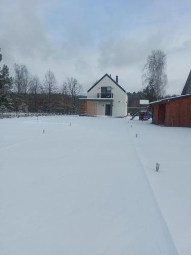 a snow covered yard with a house in the background at Lawendowa Stodoła in AdamÃ³w