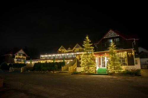 a house decorated with christmas lights in the night at Monterai Resort in Poiana Brasov