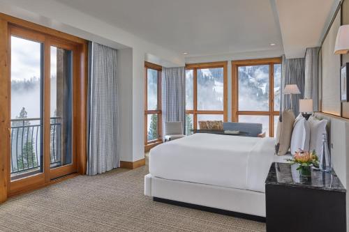 a bedroom with a large white bed and large windows at The Ritz-Carlton, Lake Tahoe in Truckee