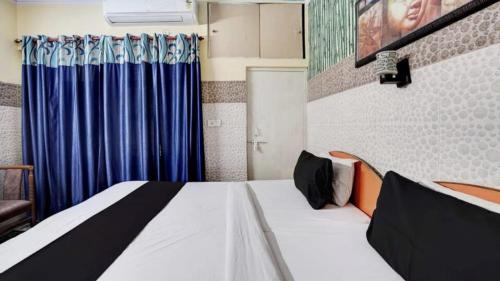 1 dormitorio con 1 cama con cortina azul en Pyrenees Homestay, en Agra