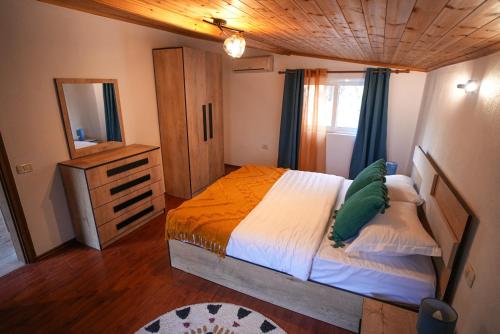 - une chambre avec un lit, une commode et un miroir dans l'établissement Grandpa House-Attic App 4, à Tirana