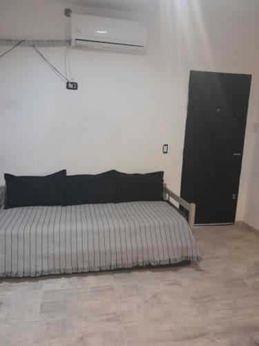 1 dormitorio con 1 cama en una habitación blanca en Departamento zona centro 1 en San Luis