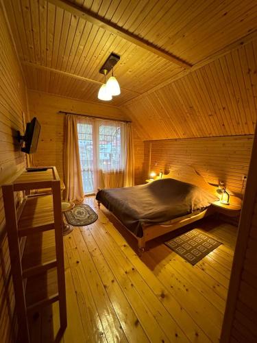 sypialnia z łóżkiem w drewnianym domku w obiekcie Бавор w Jaremczach