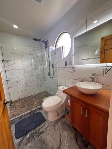 a bathroom with a shower and a toilet and a sink at Luxury Villas Arenal in Fortuna