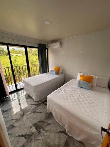 two beds in a room with a balcony at Luxury Villas Arenal in Fortuna
