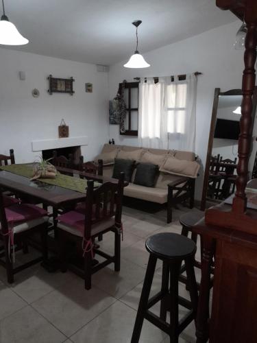 a living room with a couch and a table and chairs at Cabañas aromit in Villa Los Aromos