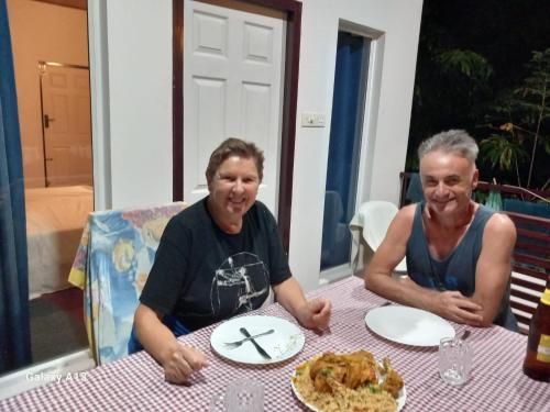 two people sitting at a table with a plate of food at Loveshore Marari in Mararikulam