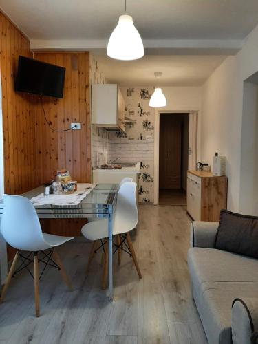 una cucina e un soggiorno con tavolo e sedie di Appartamento Casa Montagna Lory a Pozza di Fassa