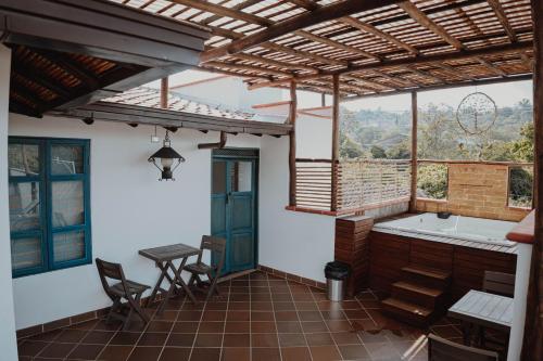 um quarto com uma banheira, uma mesa e cadeiras em Casa Silva - Hotel Cafe em Curití