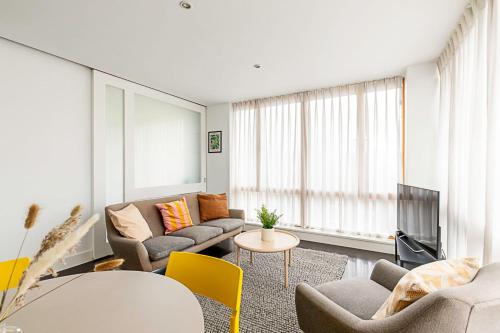 a living room with a couch and a table at Comfortable Modern Flat in Shoreditch in London