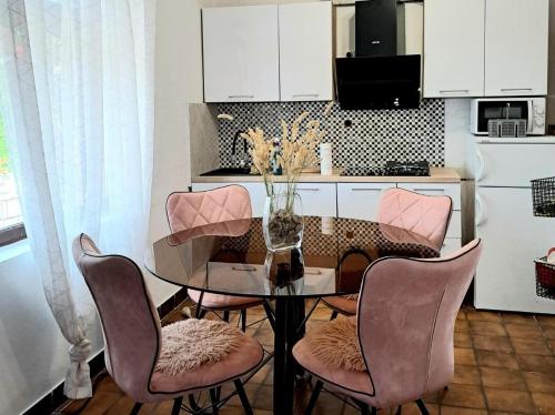 a dining room table with chairs and a vase of flowers at Holiday house Bore in Babino Polje