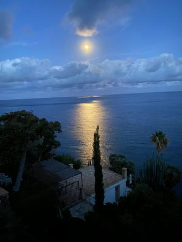 a full moon rising over the ocean at dusk at El jardin Botánico Villa LUZ in Altea