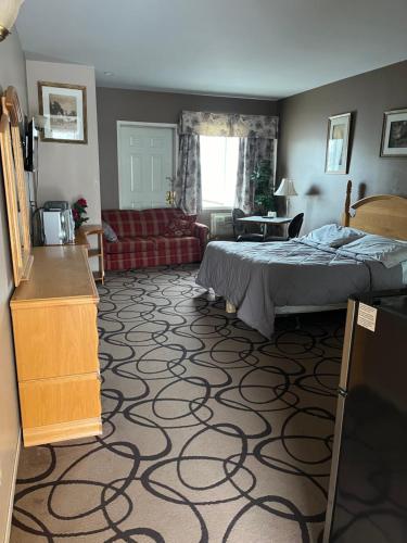 ein Schlafzimmer mit einem Bett und ein Wohnzimmer in der Unterkunft Motel la siesta de gascon in Terrebonne