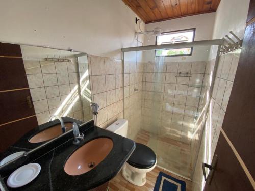 un bagno con lavandino e doccia in vetro di CASA MACEIO PRAIA DE JACARECICA a Maceió