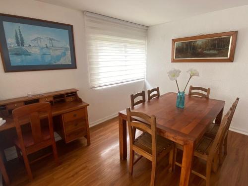 a dining room with a wooden table and a desk at La mejor ubicación de Viña in Viña del Mar