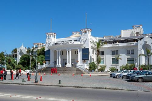 un grande edificio bianco con auto parcheggiate in un parcheggio di La mejor ubicación de Viña a Viña del Mar