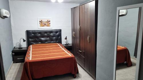 1 dormitorio con cama, silla y armario en Casa en Potrero de Garay con pileta a 100mt Rio San Pedro in 