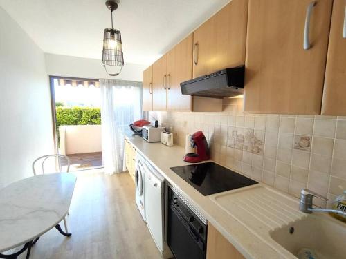 une cuisine avec un évier et un plan de travail dans l'établissement 2 pièces proche golf Mandelieu, à Mandelieu-la-Napoule