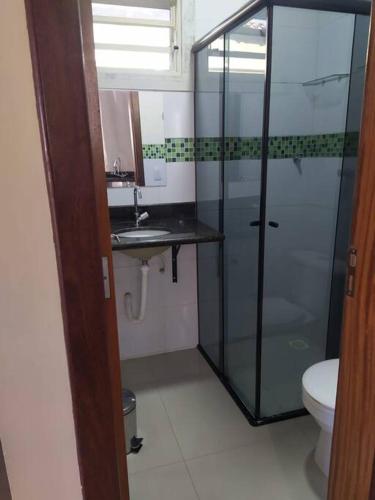 a bathroom with a glass shower and a toilet at Quitinete para casal in Brasília