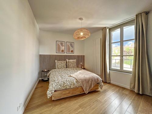um quarto com uma cama e uma grande janela em Le Patio’nnement, Troyes, Centre em Troyes