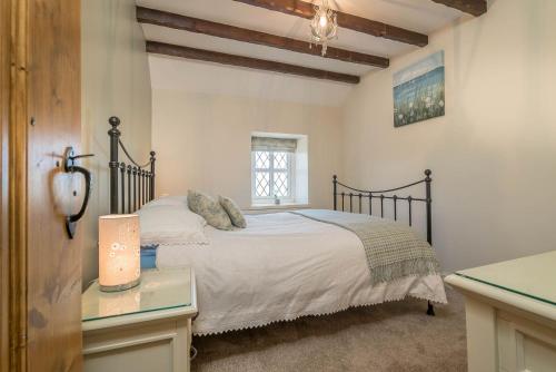 a bedroom with a bed and a desk and a window at Granar-Soch in Abersoch