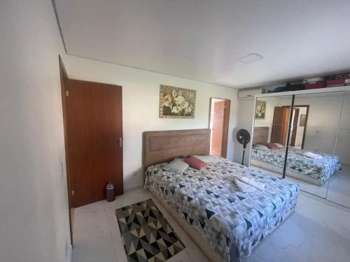 1 dormitorio con cama y espejo en Pousada Munhoz, en São Gabriel