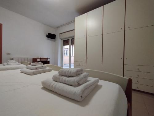 a room with four beds with towels on them at Apulia Hotel Roma in Rome