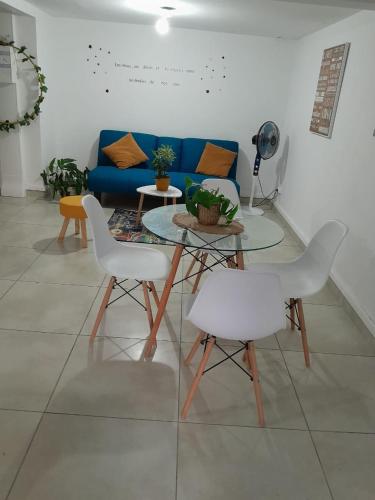 Una sala de estar con una mesa y sillas y un sofá azul. en les lau, en Sainte-Anne
