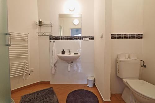 a white bathroom with a sink and a toilet at Ubytování Vila Sobotka in Sobotka