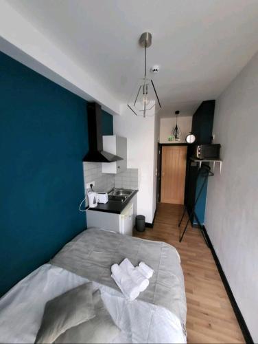 a bedroom with a large bed with a blue wall at Double room with Bathroom and kitchenette in Manchester