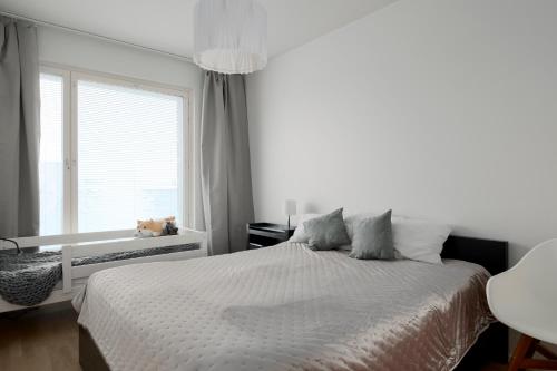 ein weißes Schlafzimmer mit einem Bett und einem Fenster in der Unterkunft New LUXUS 3BR Helsinki Home in Helsinki
