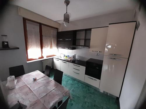 a kitchen with a table and a kitchen with white cabinets at VERCELLI CENTRO 1 in Vercelli