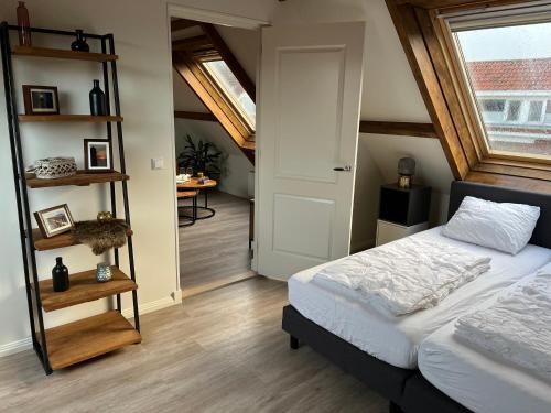 1 dormitorio con cama y estante para libros en Ruim appartement met sauna, Zuidstraat 125 in Westkapelle en Westkapelle