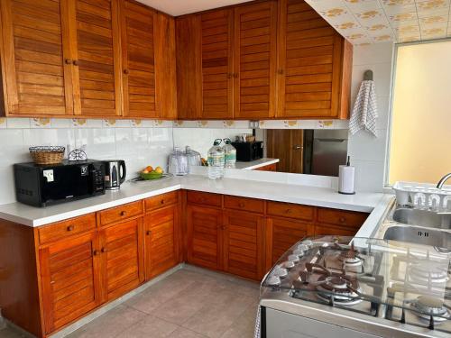a kitchen with wooden cabinets and a sink and a stove at La mejor ubicación de Viña in Viña del Mar