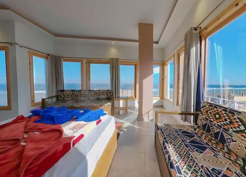 a bedroom with two beds and large windows at Seaview Hotel Dahab in Dahab