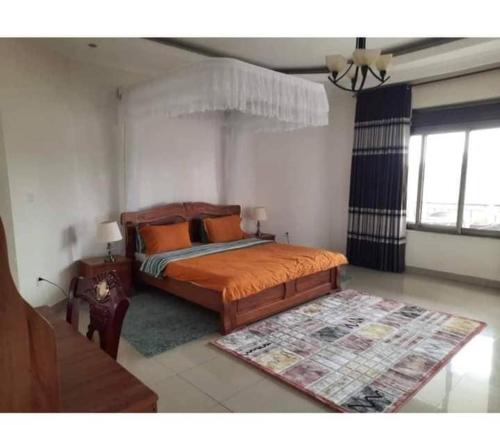 1 dormitorio con 1 cama con almohadas de color naranja en KingdomHomes., en Kigali