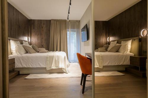 a hotel room with two beds and a mirror at Collina Luxury Relais in Clusone