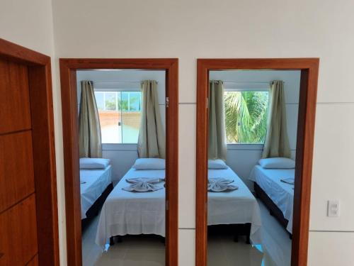 Cette chambre comprend 2 lits et 2 miroirs. dans l'établissement FLJ residencial, à Coroa Vermelha