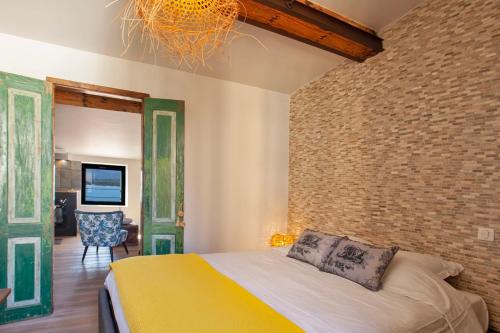 a bedroom with a bed and a brick wall at Mira appartement climatisé vue mer centre de Calvi proche port et plage in Calvi
