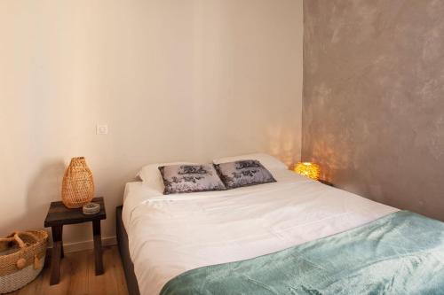 a bedroom with a bed with two pillows on it at Mira appartement climatisé vue mer centre de Calvi proche port et plage in Calvi