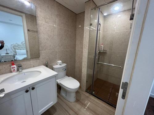 y baño con ducha, aseo y lavamanos. en royal apartment, en Hanói
