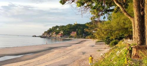 a person standing on a beach near the water at Turtle Nest in Khao Tao