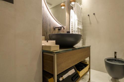 a bathroom with a vessel sink and a toilet at Collina Luxury Relais in Clusone