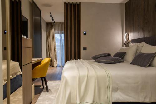 a bedroom with a large white bed and a desk at Collina Luxury Relais in Clusone
